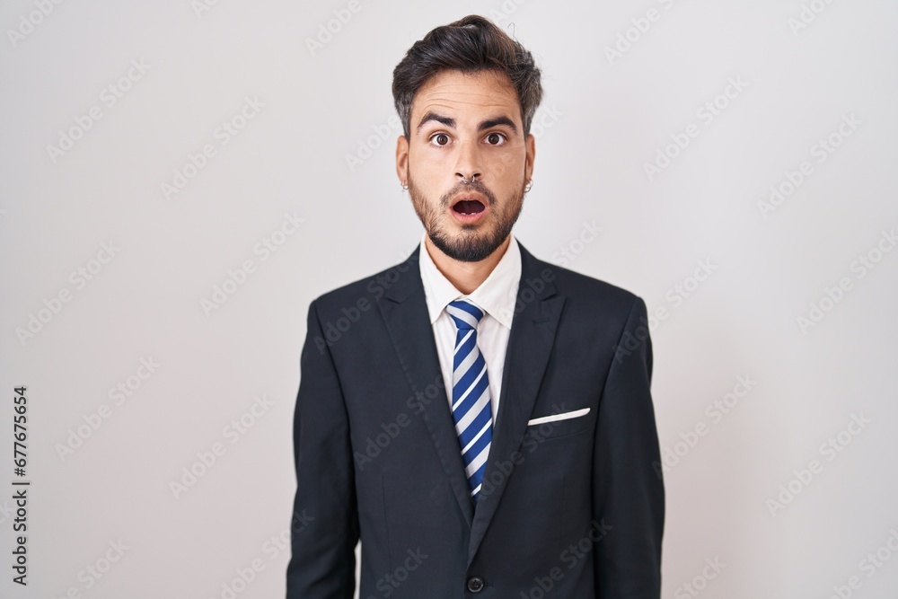 Young hispanic man with tattoos wearing business suit and tie afraid and shocked with surprise and amazed expression, fear and excited face. Young hispanic man with tattoos wearing business suit and tie afraid and shocked with surprise and amazed expression, fear and excited face.