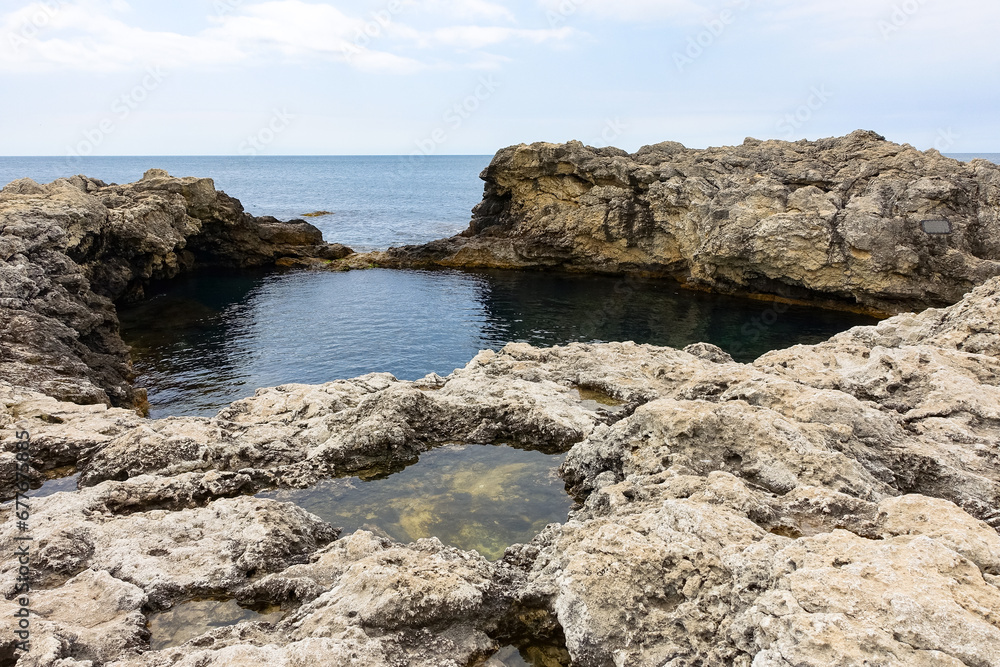 Cape Tarkhankut on the Crimean peninsula. The rocky coast of the Dzhangul Reserve in the Crimea. The Black Sea. Turquoise sea water. Rocks and grottoes of Cape Tarkhankut. Cape Tarkhankut on the Crimean peninsula. The rocky coast of the Dzhangul Reserve in the Crimea. The Black Sea. Turquoise sea water. Rocks and grottoes of Cape Tarkhankut.
