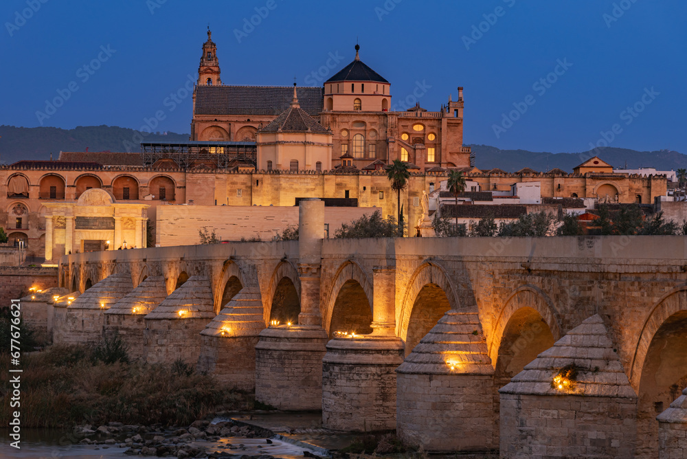 Mosque cathedral of Córdoba and the Roman bridge at dawn and with artificial lighting, Andalucia.