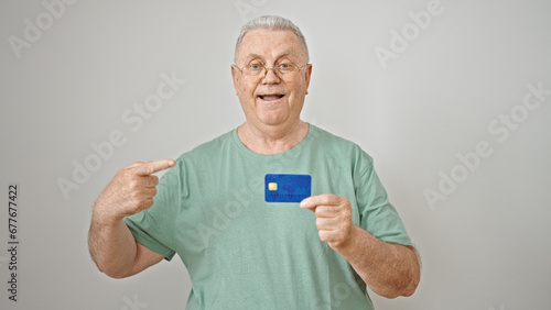 Middle age grey-haired man smiling confident pointing to credit card over isolated white background