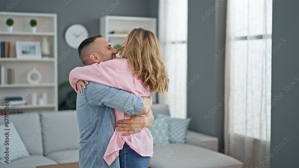 Man and woman couple hugging each other smiling at home Man and woman couple hugging each other smiling at home