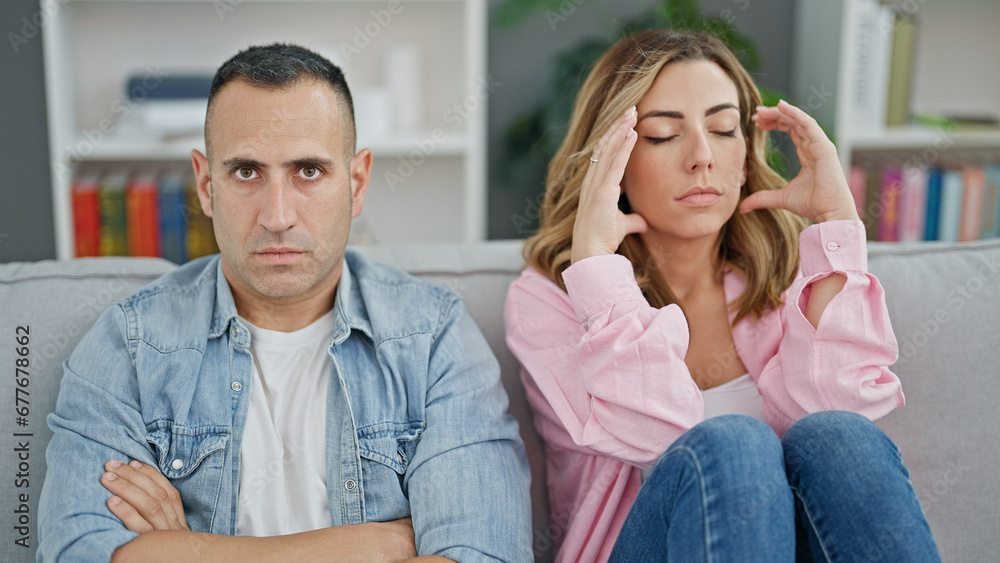Man and woman angry couple sitting on sofa together at home Man and woman angry couple sitting on sofa together at home