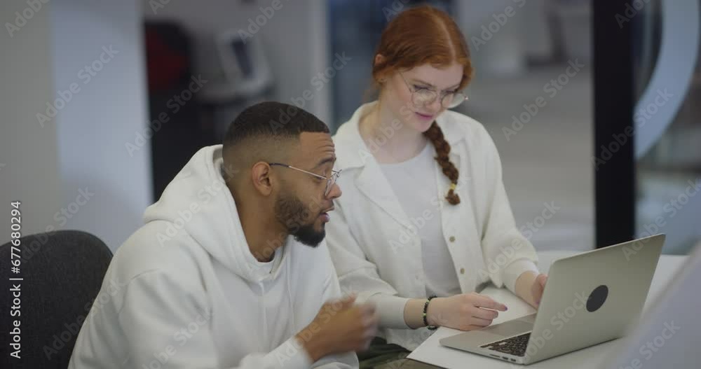 A woman with vibrant orange hair and an African-American business man work together in a modern office, collaboratively solving various business challenges, illustrating diversity, innovation, and A woman with vibrant orange hair and an African-American business man work together in a modern office, collaboratively solving various business challenges, illustrating diversity, innovation, and