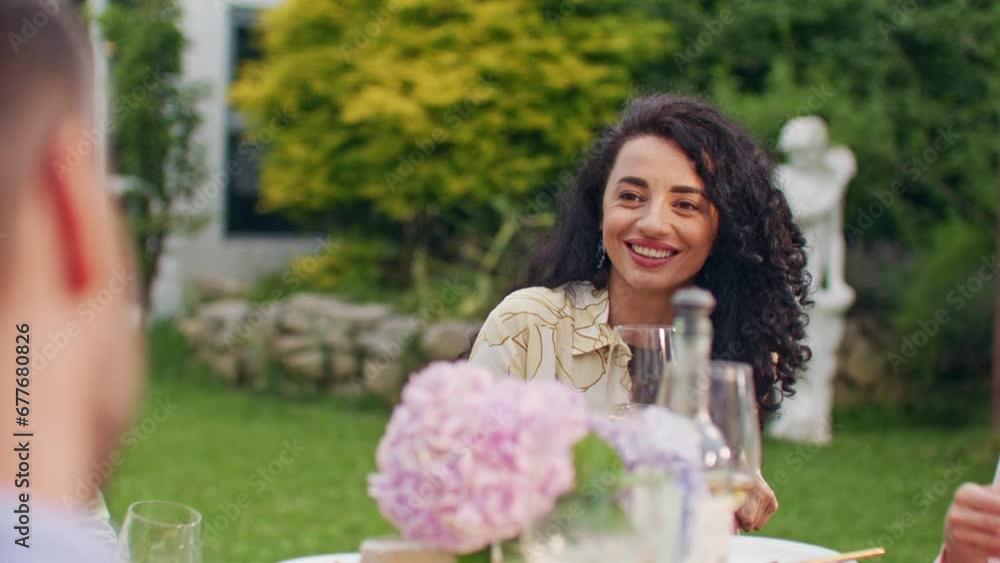 Close up of trendy stylish beautiful women rising wineglass with toasts at summer day outside. Mixed-races happy young males and females talking, laughing and toasting with drinks at party table. Close up of trendy stylish beautiful women rising wineglass with toasts at summer day outside. Mixed-races happy young males and females talking, laughing and toasting with drinks at party table.
