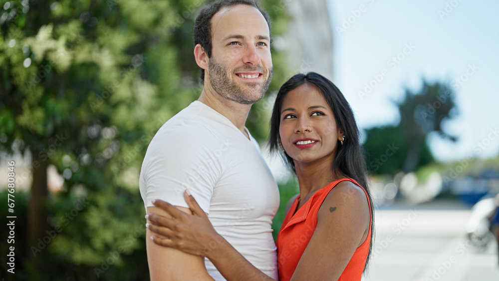 Obraz premium Beautiful couple smiling confident hugging each other at park