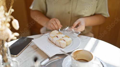 Young beautiful hispanic woman eating typical vienna sweet at cafeteria