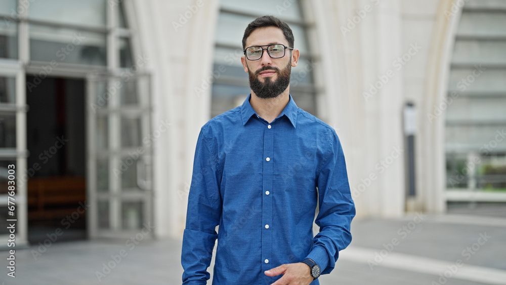 Young hispanic man business worker standing with serious face at street Young hispanic man business worker standing with serious face at street