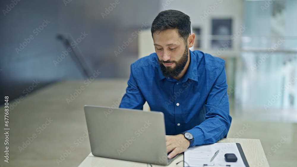 Young hispanic man business worker using laptop working at the office Young hispanic man business worker using laptop working at the office