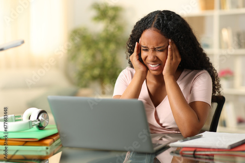 Black student suffering migraine studying at home