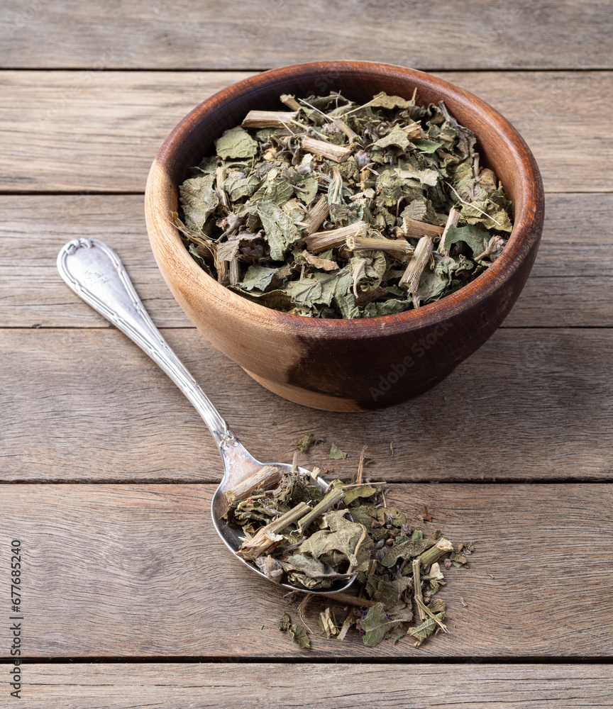 Lemon balm or Melissa dried tea leaves on a bowl over wooden table Lemon balm or Melissa dried tea leaves on a bowl over wooden table