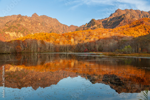 鏡池に映る朝日を浴びる紅葉の戸隠連山