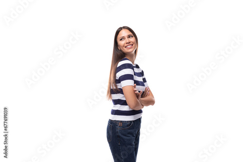 attractive young brunette woman in a striped t-shirt stands in profile on a white background with copy space