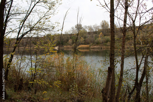 Yellow and green leaves on the trees around the lake. Autumn time in nature. Cristal clean tourquise wather. photo