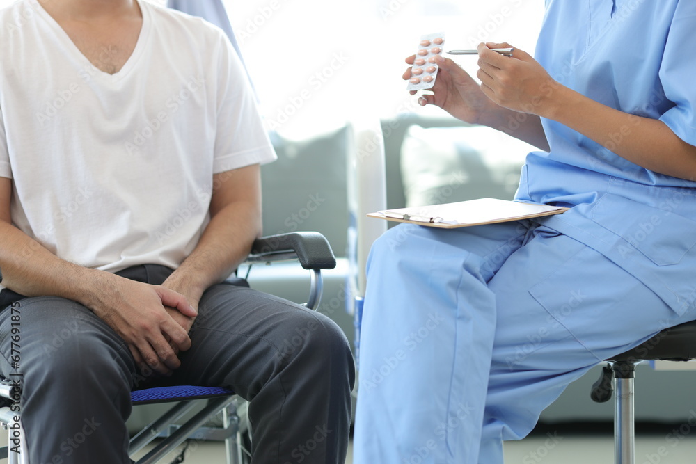 The doctor is giving advice to a man with erectile dysfunction. Patient with leg injury sitting in a wheelchair is consulting with a doctor in a hospital. Male health problem concept. The doctor is giving advice to a man with erectile dysfunction. Patient with leg injury sitting in a wheelchair is consulting with a doctor in a hospital. Male health problem concept.