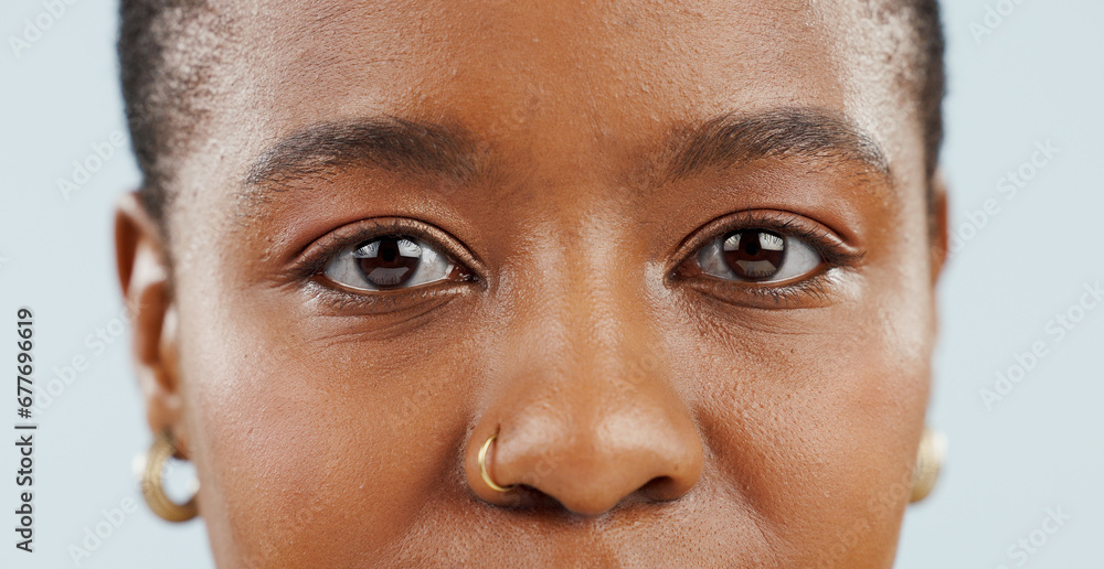 Fototapeta premium Eyes, looking and portrait of black woman in studio for vision, eyesight and focus on blue background. Healthcare, optometry and isolated face closeup of person with cosmetics, wellness and eye care