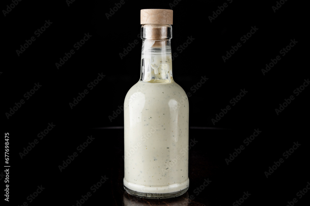 Bottle with tasty tartar sauce on black background Bottle with tasty tartar sauce on black background