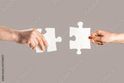 Puzzles. Man and woman holds in hand a jigsaw puzzle. Business solutions, success and strategy concept. Hands connecting puzzle. Hand of the man and hand of woman fold puzzle, closeup