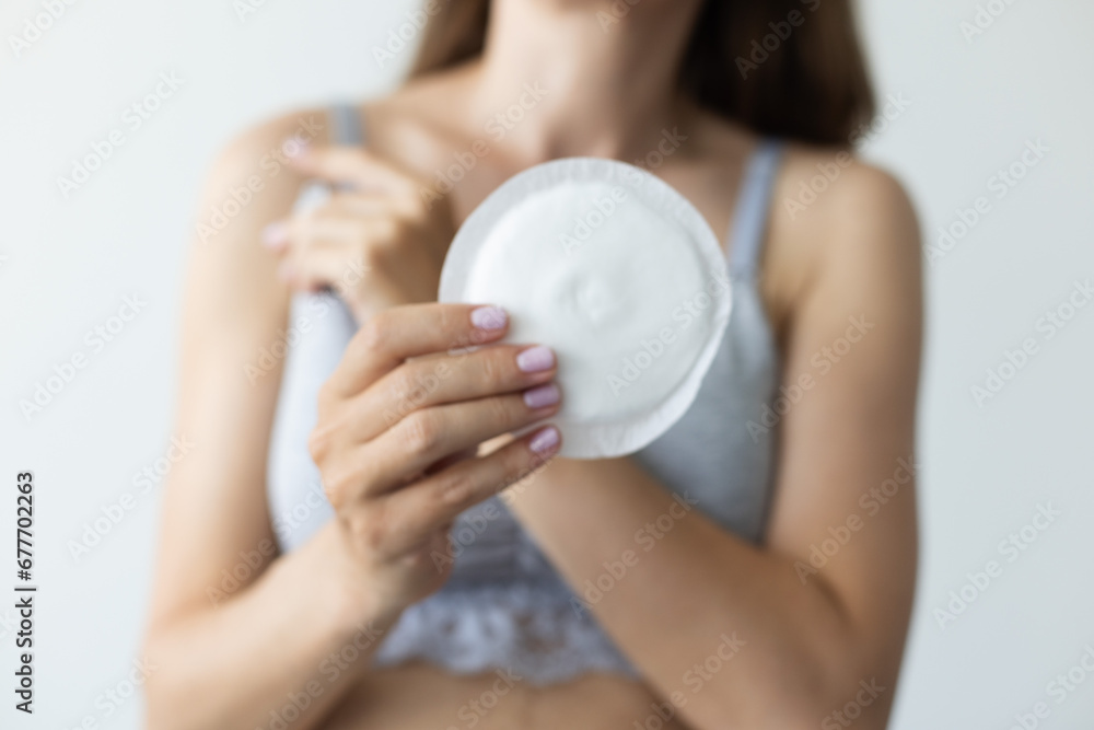 Woman holding absorbent pad for breast. Closeup, selective focus. Woman holding absorbent pad for breast. Closeup, selective focus.