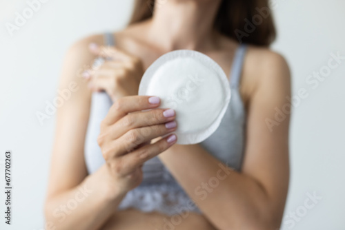 Fototapeta Naklejka Na Ścianę i Meble -  Woman holding absorbent pad for breast. Closeup, selective focus.