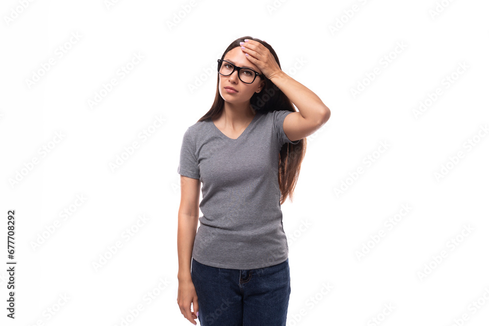 pretty brunette leader woman dressed in gray t-shirt is upset and holding her head pretty brunette leader woman dressed in gray t-shirt is upset and holding her head