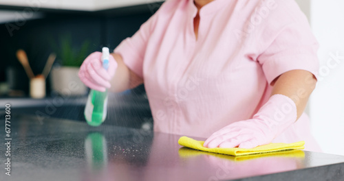 Cleaning, woman or spray on kitchen counter with detergent, housekeeper or service for home hygiene. Hands, person and cloth in housekeeping to shine, sanitizer and disinfectant for surface in house