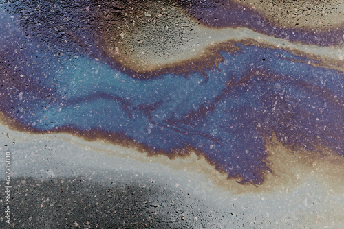 Abstract background from motor oil, gas or petrol spilled on asphalt