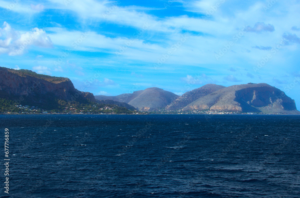 Astonishing seascape with the silhouettes of the mountains on horizon in light haze. Abstract view of the sea and the land. Travel and tourism concept Astonishing seascape with the silhouettes of the mountains on horizon in light haze. Abstract view of the sea and the land. Travel and tourism concept