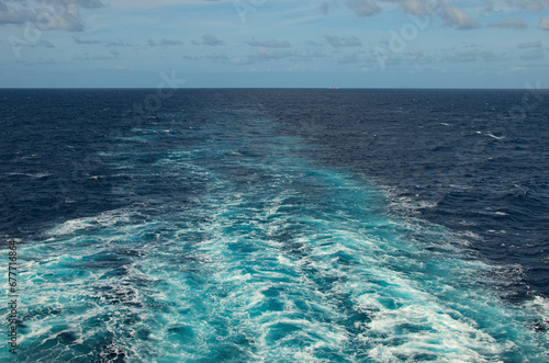 Wake of a cruise ship on the open ocean. Water trail in the sea tlt ocean behind a cruise liner. Transport and travel concept. Sea wake behind a cruise ship
