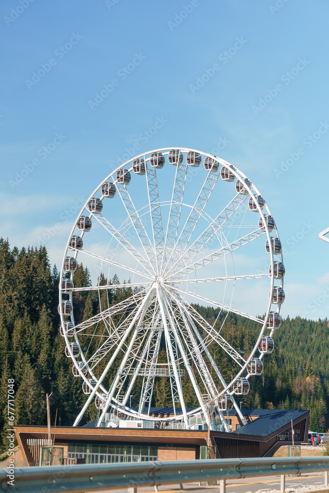 Big tall white ferris wheel in front of perfect blue sky in Bukovel. Carpathians Ukraine Big tall white ferris wheel in front of perfect blue sky in Bukovel. Carpathians Ukraine