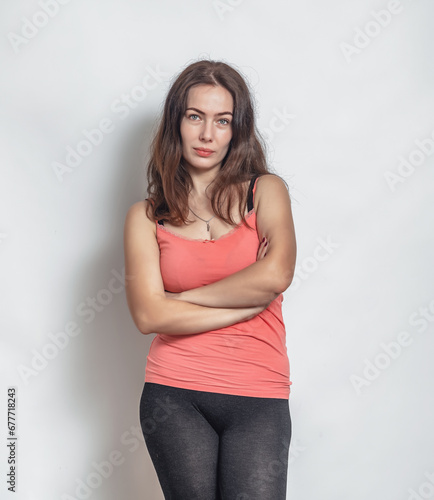 Slim dark-haired woman posing in the studio. Mysterious smile. White background.
