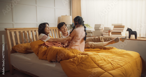 Canvas Print Happy Korean Family in the Morning: Active and Playful Child Running to her Parents' Bedroom to Wake Them Up