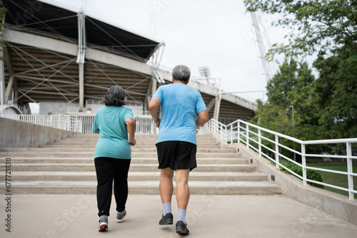 Happy and smile couples elderly asian running on stairs for workout, jogging on morning, senior exercise outdoors for good healthy. Concept of healthcare and active lifestyle for healthy