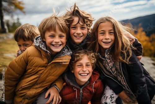 Grupo de amigos alegres niños con caras sonrientes posando en al aire libre en un día soleado de otoño, los niños y las niñas emocionados que se divierten durante la actividad en la naturaleza. photo