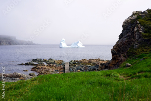 Iceberg in a bay close to a rocky shore in early summer near Twillingate photo