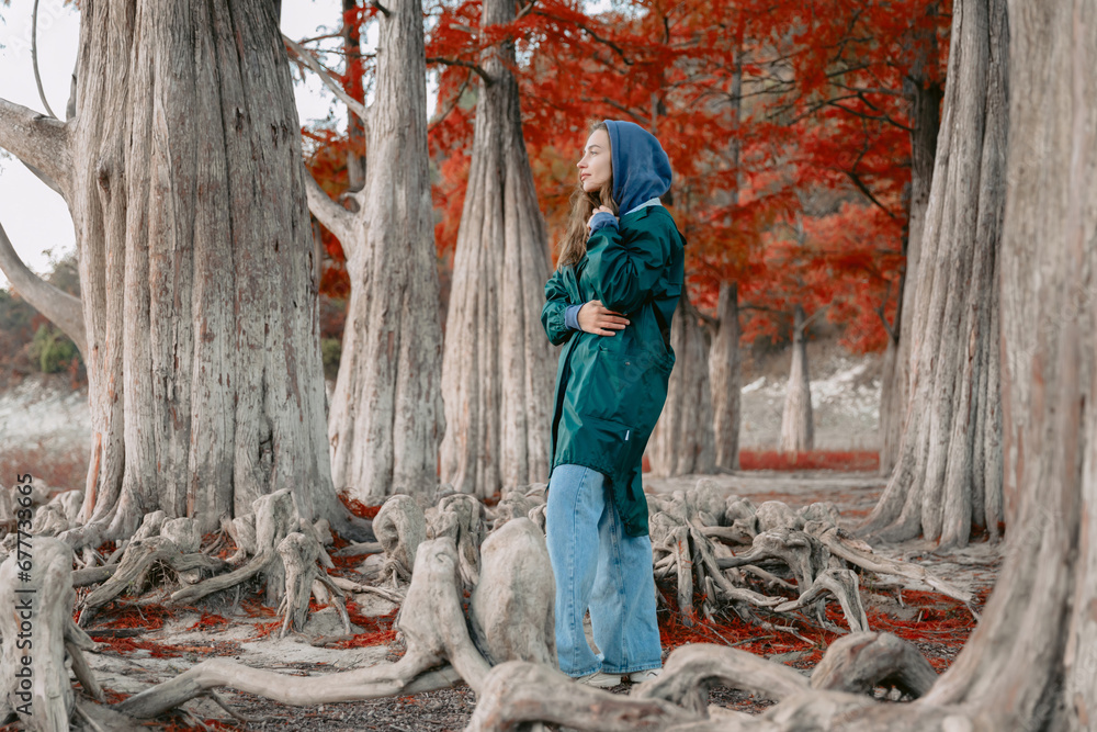 Woman walking among trees in park. Portrait of people in park in autumn. Woman walking among trees in park. Portrait of people in park in autumn.