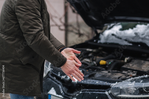 Middle selection of man clean his hands after repairing the car's malfunction. Back ground of open hood