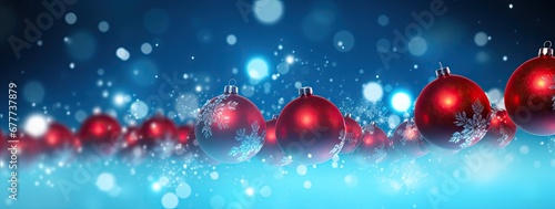  a row of red christmas baubles on a blue background with snow flakes on the bottom of the baubles.