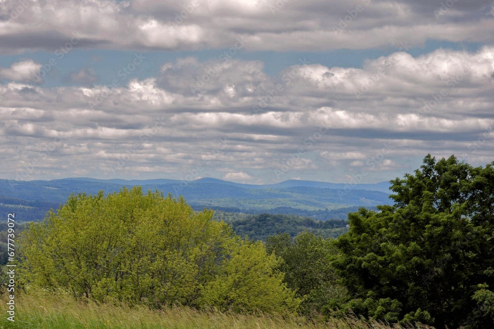 Beautiful landscape of the White Mountains and green trees under the cloudy sky in Littleton