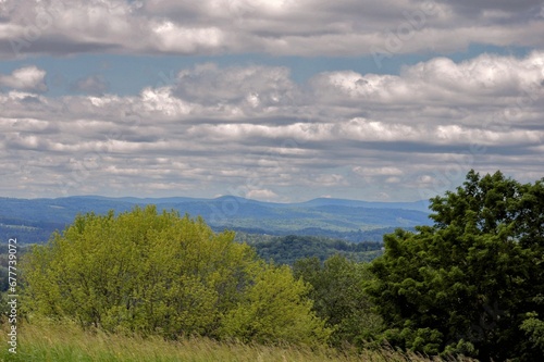 Beautiful landscape of the White Mountains and green trees under the cloudy sky in Littleton photo