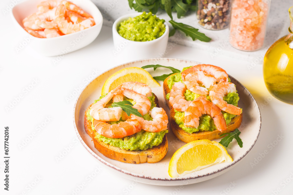 Shrimps on toast with avocado and lemon. Prawns. Breakfast concept. Bruschetta. Shrimps on toast with avocado and lemon. Prawns. Breakfast concept. Bruschetta.