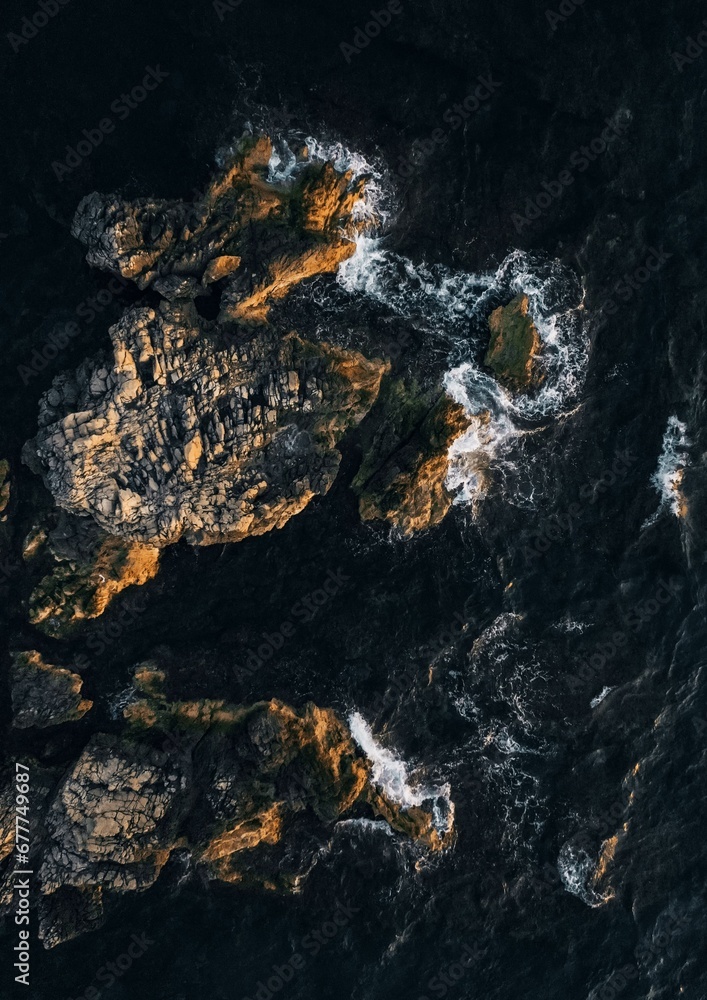 Vertical top view over the sea waves crashing on the rocks Vertical top view over the sea waves crashing on the rocks