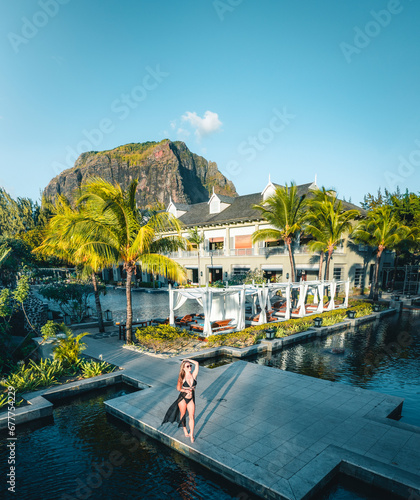 Aerial view of a woman along the swimming pool of luxury resort, Riviere Noire, Le Morne Brabant, Mauritius. photo