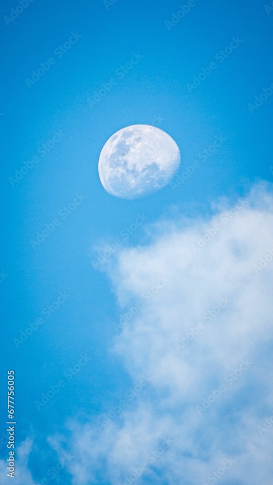 Moon on a blue day sky