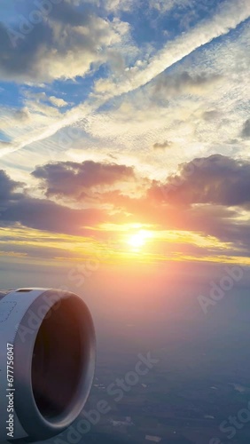 airplane flying thru beautiful fluffy clouds in sunset- copy space vertical backgound photo