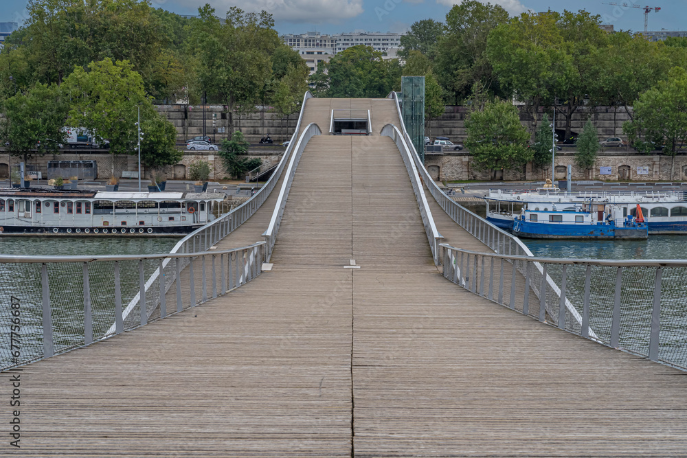Paris, France - 09 20 2021: Simone de Beauvoir footbridge. View of the wooden bridge with the Bercy Park behind.