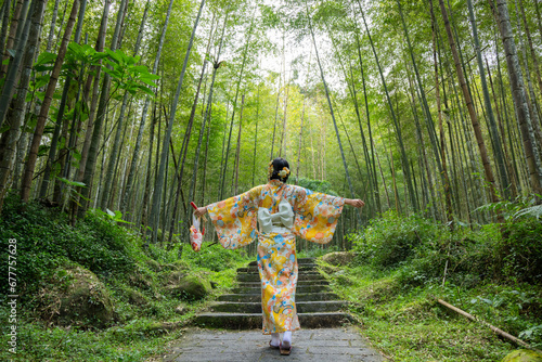 Woman wear kimono in the bamboo forest photo