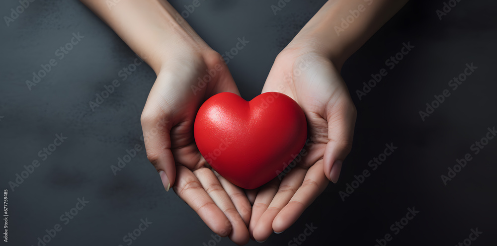 Female hand holding red heart isolated on blue background Female hand holding red heart isolated on blue background