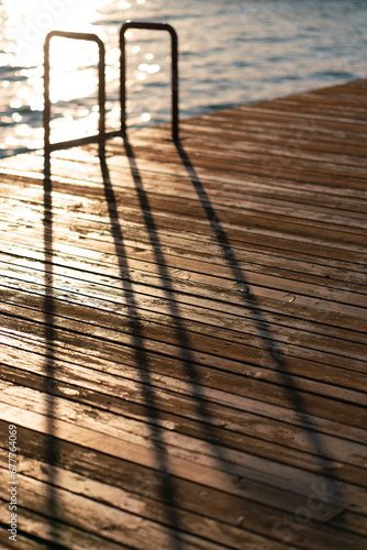 Defocused image of a pontoon, stairs in the swimming pool at beach or the resort. The dreaming of a summer vacation at sea. Minimalism style.