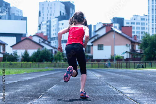 Fit girl exercising outdoors. Healthy young female athlete doing fitness workout. Sportsgirl do functional training outside, wearing sport outfit. Horizontal image.