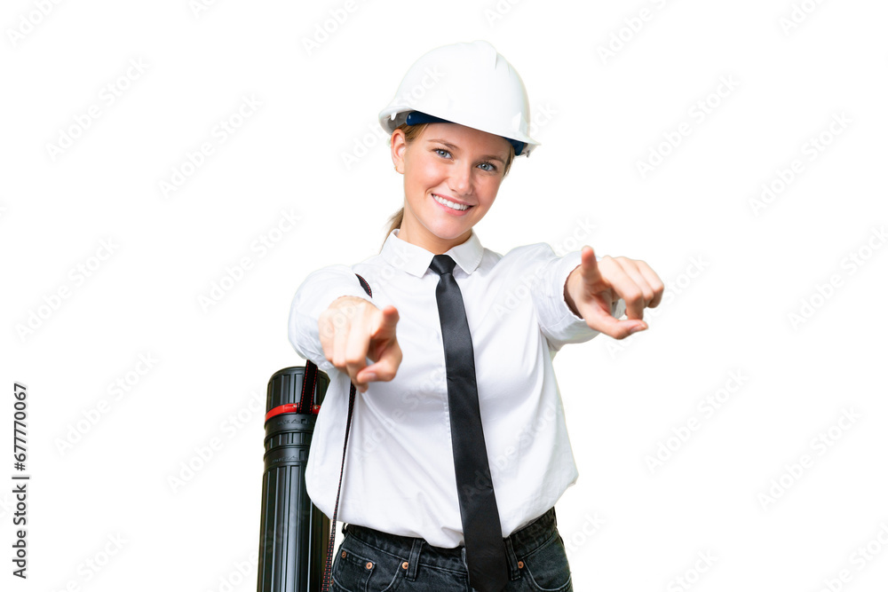Young architect caucasian woman with helmet and holding blueprints over isolated background points finger at you while smiling Young architect caucasian woman with helmet and holding blueprints over isolated background points finger at you while smiling